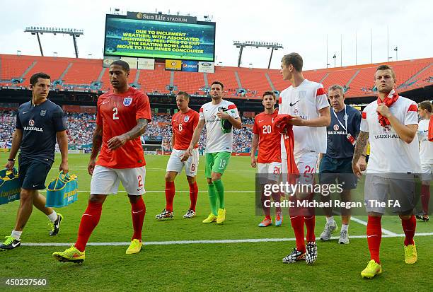 Team England walk off the field after the game being delayed due to inclement weather during the International Friendly match between England and...