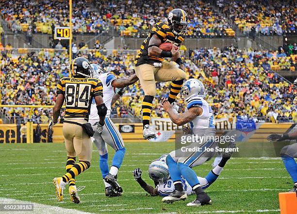 Le'Veon Bell of the Pittsburgh Steelers jumps to avoid a tackle by Willie Young of the Detroit Lions in front of Glover Quin on November 17, 2013 at...