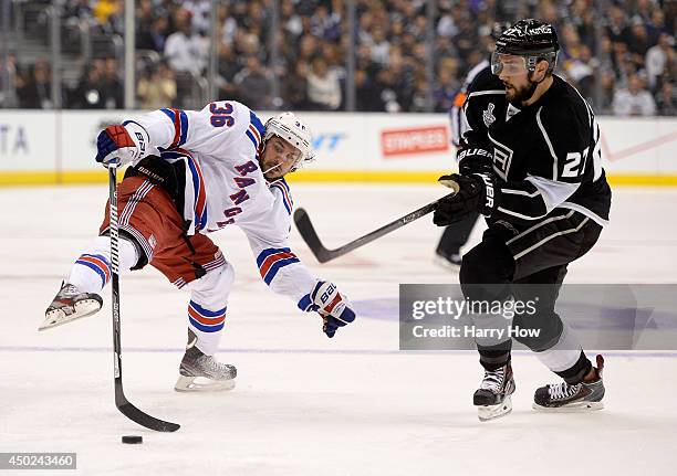 Mats Zuccarello of the New York Rangers and Alec Martinez of the Los Angeles Kings go after the puck in the first period during Game Two of the 2014...