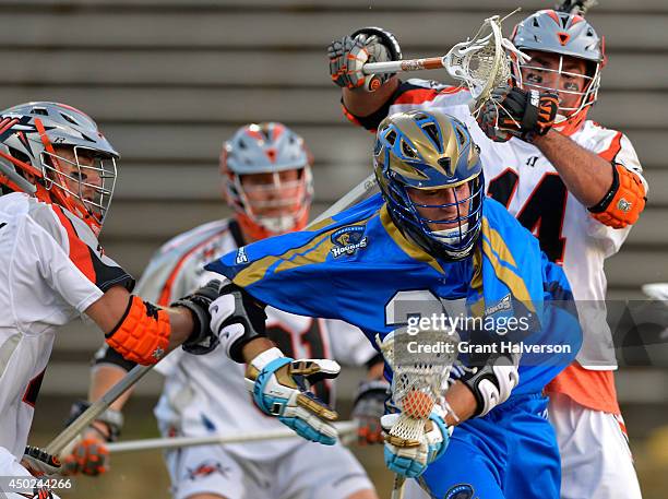 Chris O'Dougherty and Justin Pennington of the Denver Outlaws pressure Ryan Young of the Charlotte Hounds at American Legion Memorial Stadium on June...