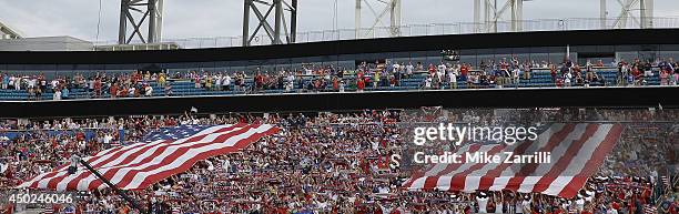 Fans stand and hold two flags for the United States national anthem before the international friendly match against Nigeria at EverBank Field on June...