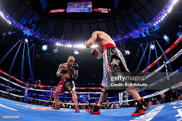 Miguel Cotto of Puerto Rico fights Sergio Martinez of Argentina in the sixth round of their WBC Middleweight Championship fight on June 7, 2014 at...