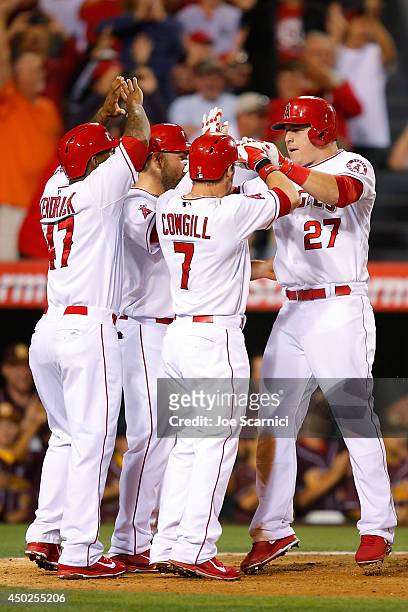 Mike Trout of the Los Angeles Angels celebrates with Collin Cowgill and Howie Kendrick after hitting a grand slam home run to tie the game in the...