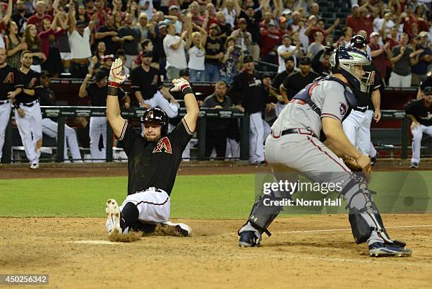 Cody Ross of the Arizona Diamondbacks scores the winning run in the 11th inning on teammate Gerardo Parra's hit against the Atlanta Braves at Chase...