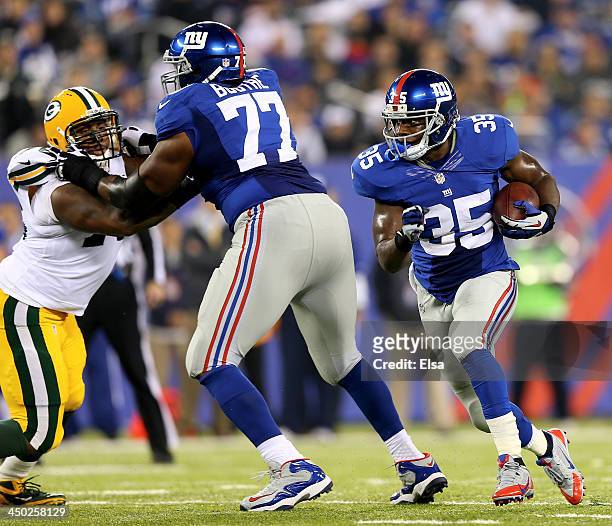Andre Brown of the New York Giants carries the ball as Kevin Boothe blocks against the Green Bay Packers at MetLife Stadium on November 17, 2013 in...