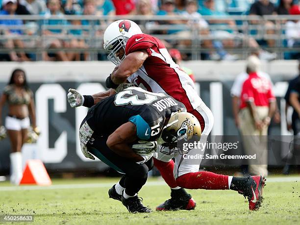 Yeremiah Bell of the Arizona Cardinals tackles Kerry Taylor of the Jacksonville Jaguars during the game at EverBank Field on November 17, 2013 in...