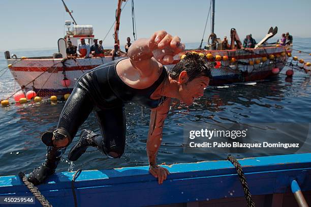 Fisherman climbs on to a boat after fishing bluefin tunas during the end of the Almadraba tuna fishing season on June 3, 2014 near the Barbate coast,...