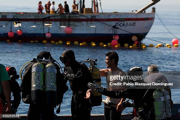 Fishermen get ready to dive and pick up nets from underwater as they prepare to fish bluenfin tunas during the end of the Almadraba tuna fishing...