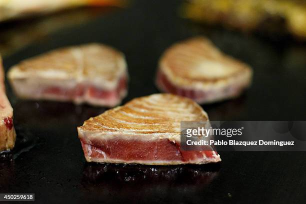 Pieces of red tuna are cooked on a griddle inside El Campero Restaurant during the end of the Almadraba tuna fishing season on June 3, 2014 in...