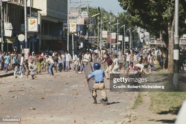 Riot police are pelted with stones during an anti-government general strike in Dhaka, Bangladesh, circa 1989.