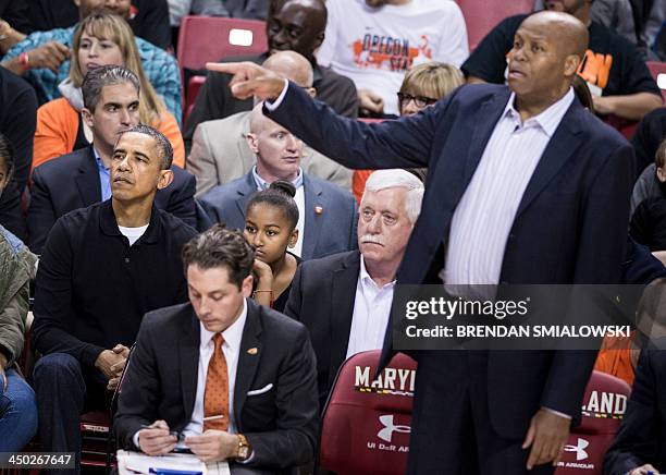 President Barack Obama watches as his brother-in-law Craig Robinson coaches during a basketball game at the University of Maryland's Comcast Center...