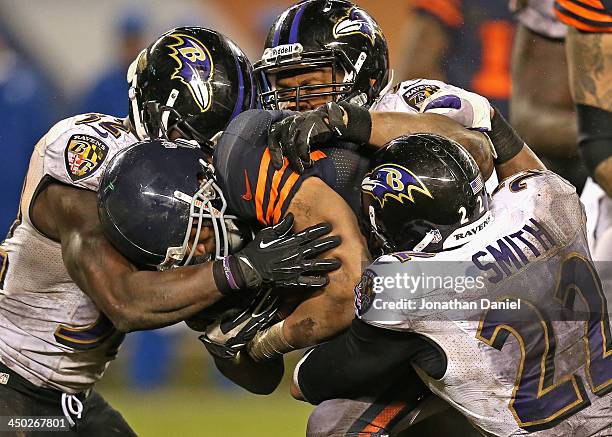 Matt Forte of the Chicago Bears is hit by James Ihedigbo, Daryl Smith and Jimmy Smith of the Baltimore Ravens at Soldier Field on November 17, 2013...