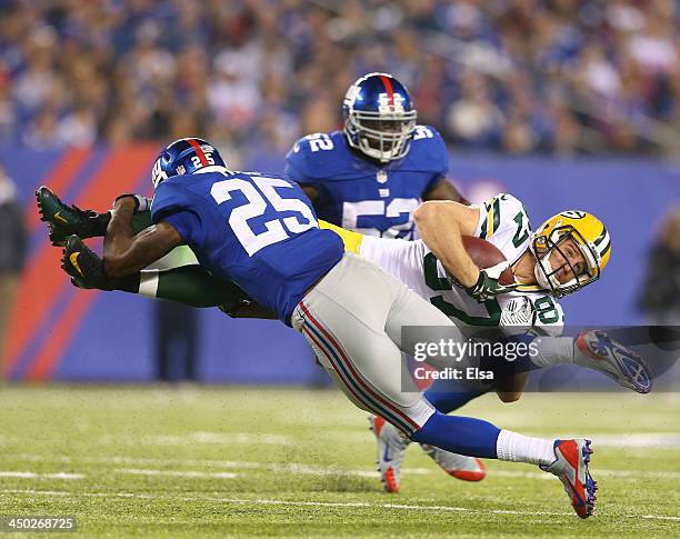 Jordy Nelson of the Green Bay Packers collides with Will Hill of the New York Giants as Jon Beason of the Giants stands by in the second half at...