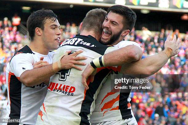 Chris Lawrence of the Tigers celebrates a try with team mate James Tedesco during the round 13 NRL match between the Newcastle Knights and the Wests...