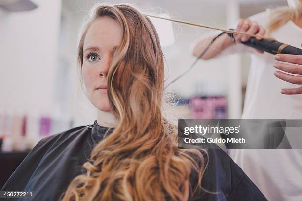 woman getting curls in coiffeur studio - hairdresser foto e immagini stock