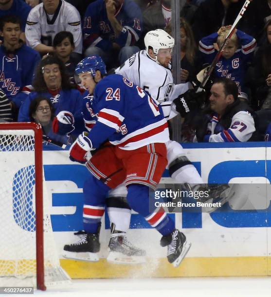 Ryan Callahan of the New York Rangers hits Jake Muzzin of the Los Angeles Kings against the boards during the first period at Madison Square Garden...