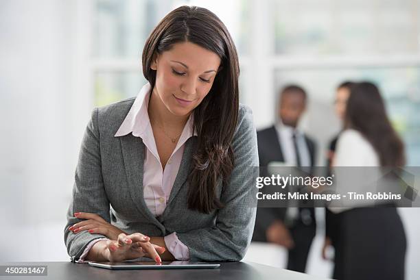 a city office. a woman in a grey jacket, using a digital tablet.  - straight hair stock pictures, royalty-free photos & images