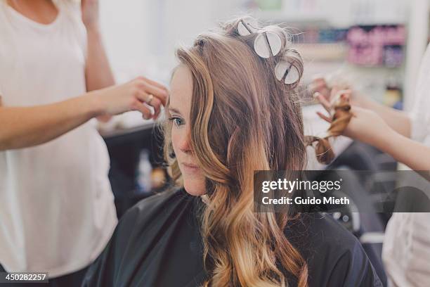 woman getting curls from hairdressers - hair curlers stock-fotos und bilder