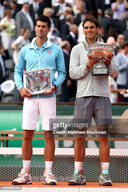 Rafael Nadal of Spain holds the Coupe de Mousquetaires as he poses with Novak Djokovic of Serbia after their men's singles final match on day fifteen...