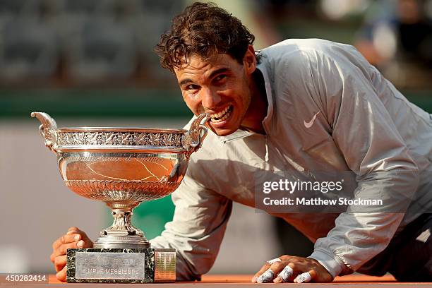 Rafael Nadal of Spain bites the Coupe de Mousquetaires after victory in his men's singles final match against Novak Djokovic of Serbia on day fifteen...