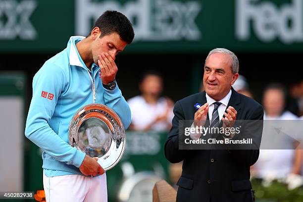 President of the FFT Jean Gachassin applauds Novak Djokovic of Serbia after his defeat in the men's singles final match against Rafael Nadal of Spain...