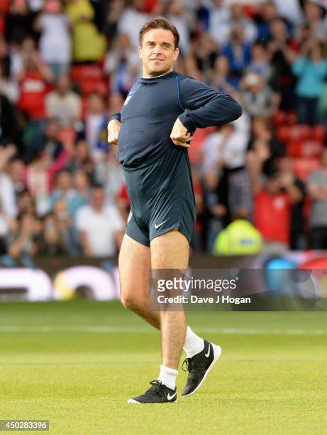 England assistant manager Robbie Williams pulls his shorts up on the pitch ahead of Soccer Aid 2014 at Old Trafford on June 8, 2014 in Manchester,...