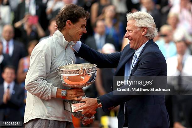 Rafael Nadal of Spain is presented with the Coupe de Mousquetaires by Bjorn Borg after his men's singles final match against Novak Djokovic of Serbia...