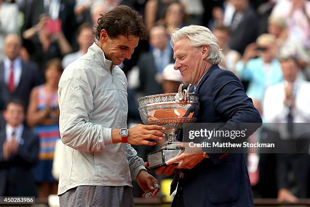 Rafael Nadal of Spain is presented with the Coupe de Mousquetaires by Bjorn Borg after his men's singles final match against Novak Djokovic of Serbia...
