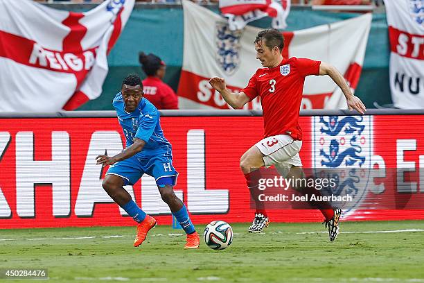 Leighton Baines of England brings the ball up field while being defended by Marvin Chavez of Honduras on June 7, 2014 during an International...