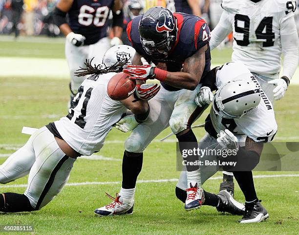 Ben Tate of the Houston Texans fumbles the ball after taking a hard hit by Charles Woodson of the Oakland Raiders and Mike Jenkins at Reliant Stadium...