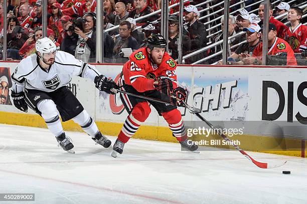 Bryan Bickell of the Chicago Blackhawks and Drew Doughty of the Los Angeles Kings chase the puck in Game Seven of the Western Conference Final during...