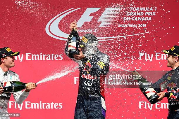Racewinner Daniel Ricciardo of Australia and Infiniti Red Bull Racing is sprayed with champagne by second placed Nico Rosberg of Germany and Mercedes...