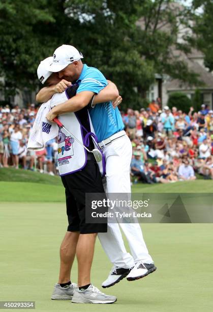 Ben Crane celebrates with caddie Joel Stock during the final round of the FedEx St. Jude Classic at the TPC Southwind on June 8, 2014 in Memphis,...