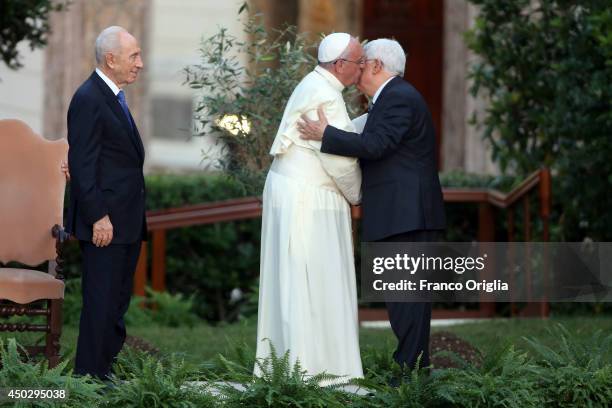 Pope Francis kisses Palestinian President Mahmoud Abbas as Israeli President Shimon Peres looks in during a peace invocation prayer at the Vatican...