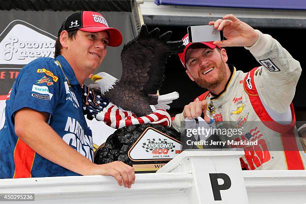 Dale Earnhardt Jr., driver of the National Guard Chevrolet, right, and crew chief Steve Letarte take a selfie in Victory Lane after winning the...
