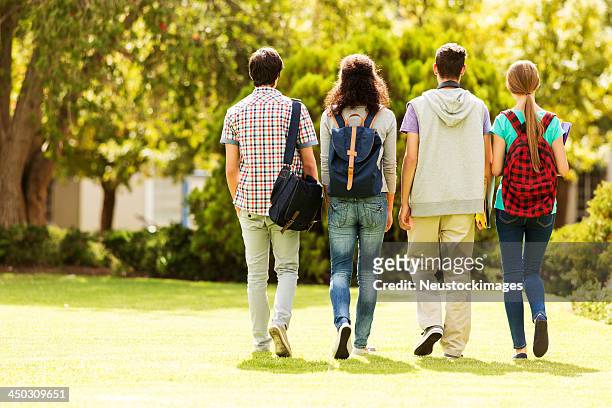 vista traseira de um aluno grupo caminhar no campus - teenagers only imagens e fotografias de stock