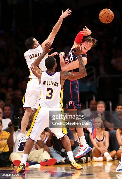 Jonas Jerebko of the Detroit Pistons passes off the ball away from Jordan Farmar and Shawne Williams of the Los Angeles Lakers at Staples Center on...