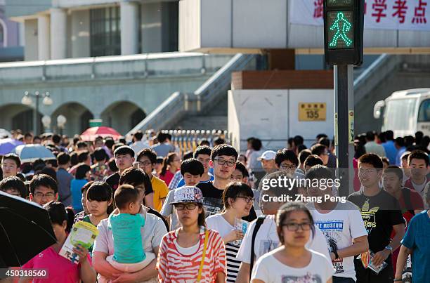 Crowd of students walk across the road in front of the high school where they have just finished their college entrance examination. In 2014, 9.39...