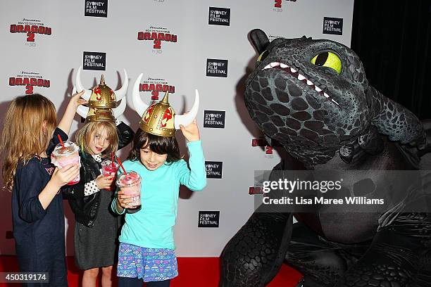 Young girls stand close to Toothless the dragon at the 'How To Train Your Dragon 2' Australian premiere at Event Cinemas George Street on June 9,...