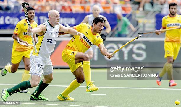 Australia's Glenn Turner in action with India's Dharamvir Singh van Indiai during the stage match between Australia and India in the men's tournament...