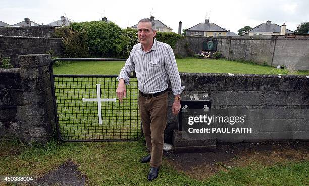 Irish writer John Pascal Rodgers poses for a photograph as he stands beside a shrine in Tuam, County Galway on June 9 erected in memory of up to 800...