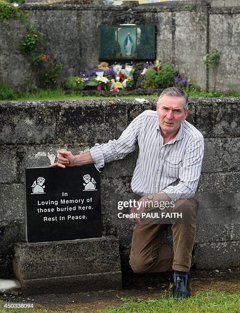 Irish writer John Pascal Rodgers poses for a photograph as he stands beside a shrine in Tuam, County Galway on June 9 erected in memory of up to 800...