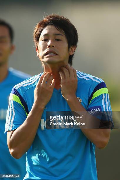 Atsuto Uchida scratches his neck during a Japan training session at the Japan national team base camp at the Spa Sport Resort on June 9, 2014 in Itu,...