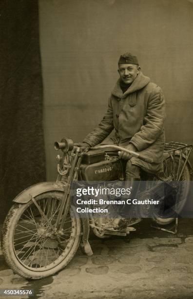 Army Lieutenant sits astride a battle-weary Harley-Davidson FUS dispatch motorcycle posed outside a French photo studio in the winter months...