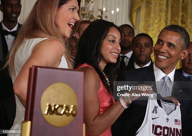 President Barack Obama receives a jersey from point guard Bria Hartley and center Stefanie Dolson of the University of Connecticut women's basketball...