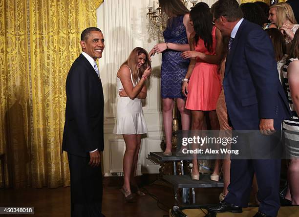 Center Stefanie Dolson of the University of Connecticut women's basketball team laughs with U.S. President Barack Obama looks on after she slips off...