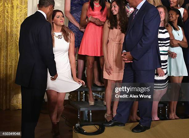 Center Stefanie Dolson of the University of Connecticut women's basketball team curtsies as U.S. President Barack Obama looks on after she slips off...