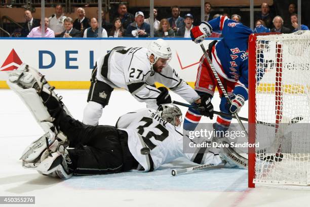 Goaltender Jonathan Quick of the Los Angeles Kings makes a save next to teammate Alec Martinez and Mats Zuccarello of the New York Rangers in the...
