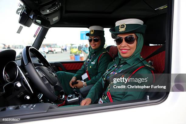 Female Emerati police officers smile as they sit inside their Mercedes Benz Brabus 4x4 supercar during the Dubai Airshow on November 18, 2013 in...