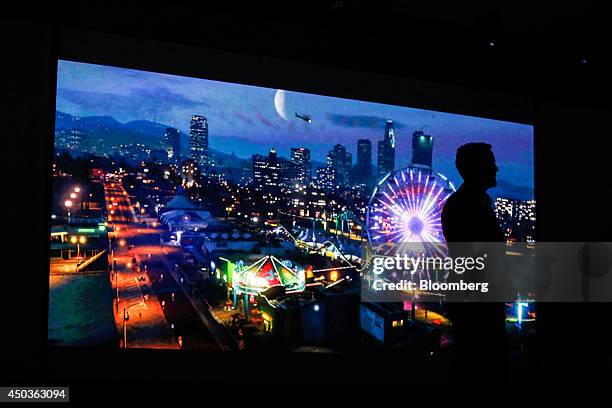Andrew House, president and chief executive officer of Sony Computer Entertainment Inc., is silhouetted as he watches a trailer for the Grand Theft...